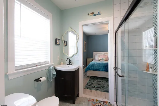 a bathroom with a sink a toilet and shower