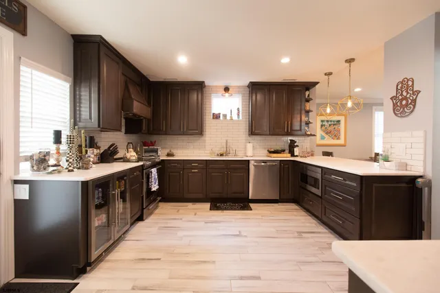 a large kitchen with kitchen island granite countertop a sink refrigerator and cabinets