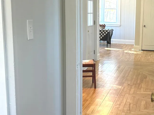 a view of a bedroom with wooden floor and a window