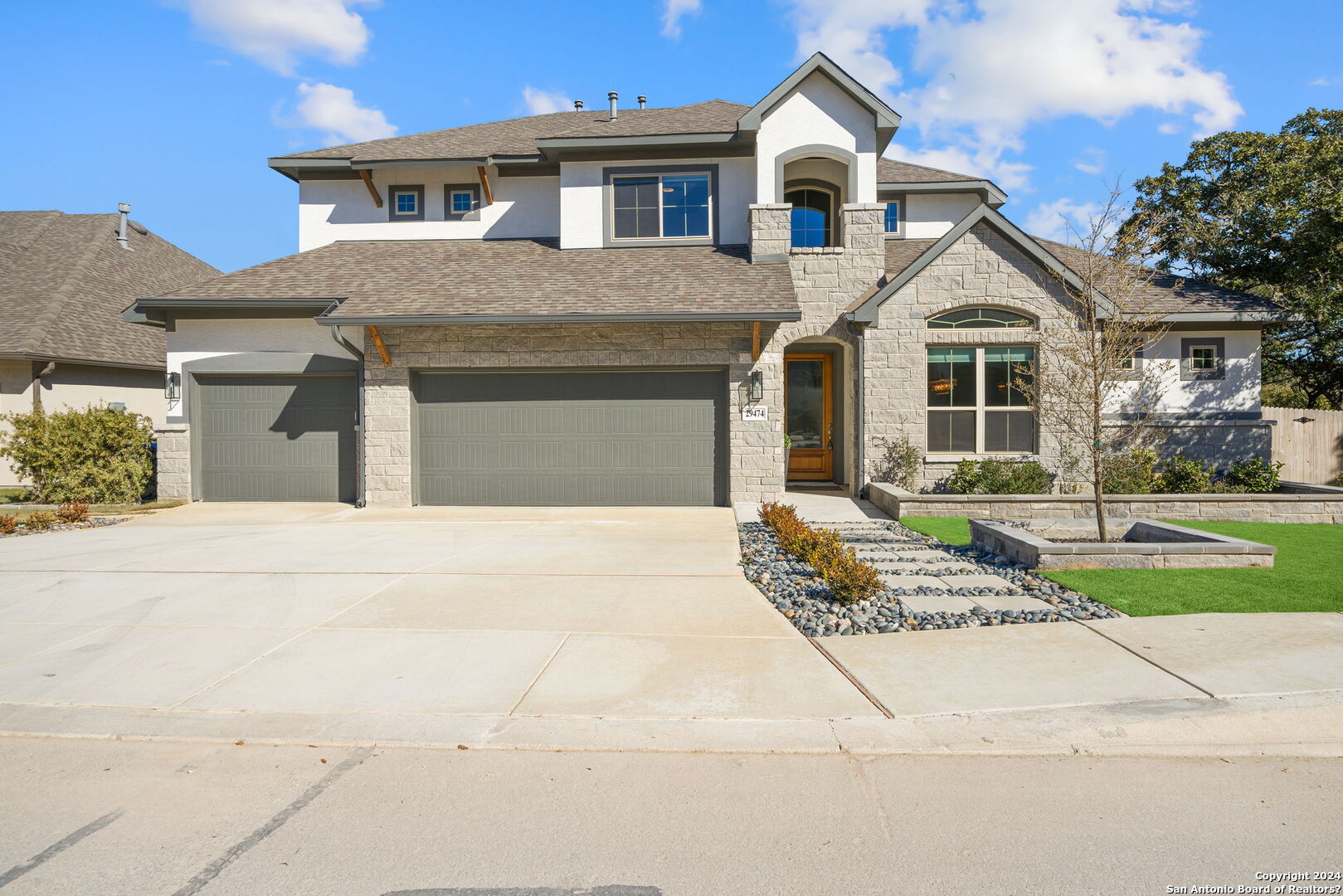 a front view of a house with a garden and trees