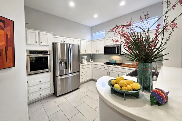 a kitchen with stainless steel appliances a stove a refrigerator and a microwave