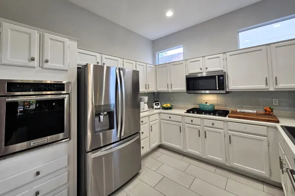 a kitchen with cabinets stainless steel appliances and a counter space