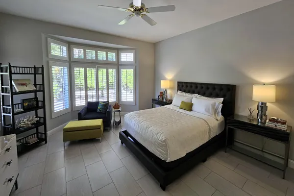 a bedroom with a bed and a large window