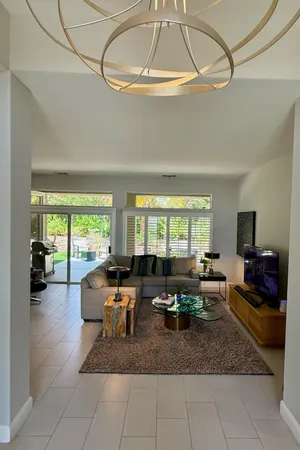 a living room with fireplace furniture and a large window