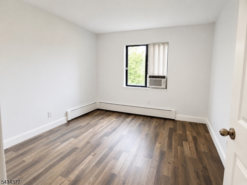 207 Old Chimney Ridge Road, Unit B Montague, NJ 07827 - Photo 6 of 10 an empty room with wooden floor and windows