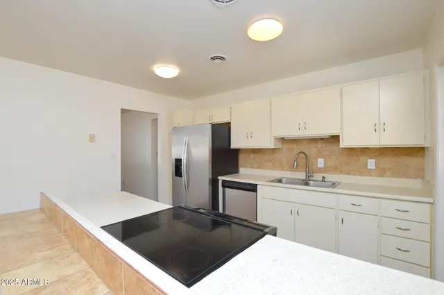 a kitchen with a sink and white cabinets