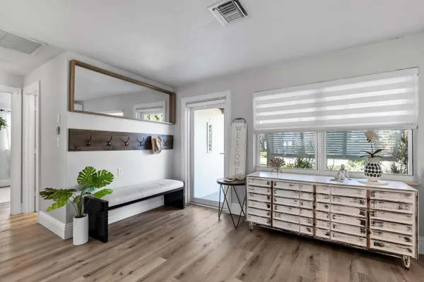 a living room with furniture kitchen view and a large window