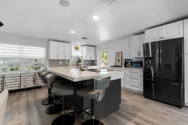 a kitchen with a refrigerator and wooden floor