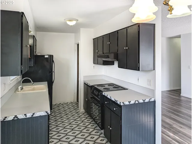 a kitchen with a refrigerator and a stove top oven