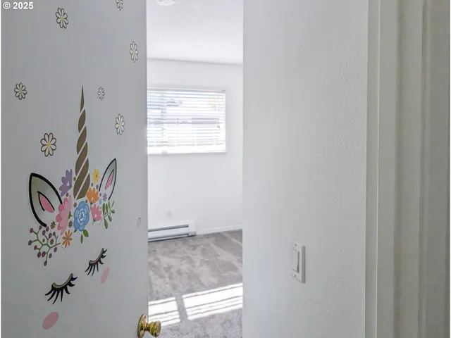a bathroom with a painting on the wall and a window