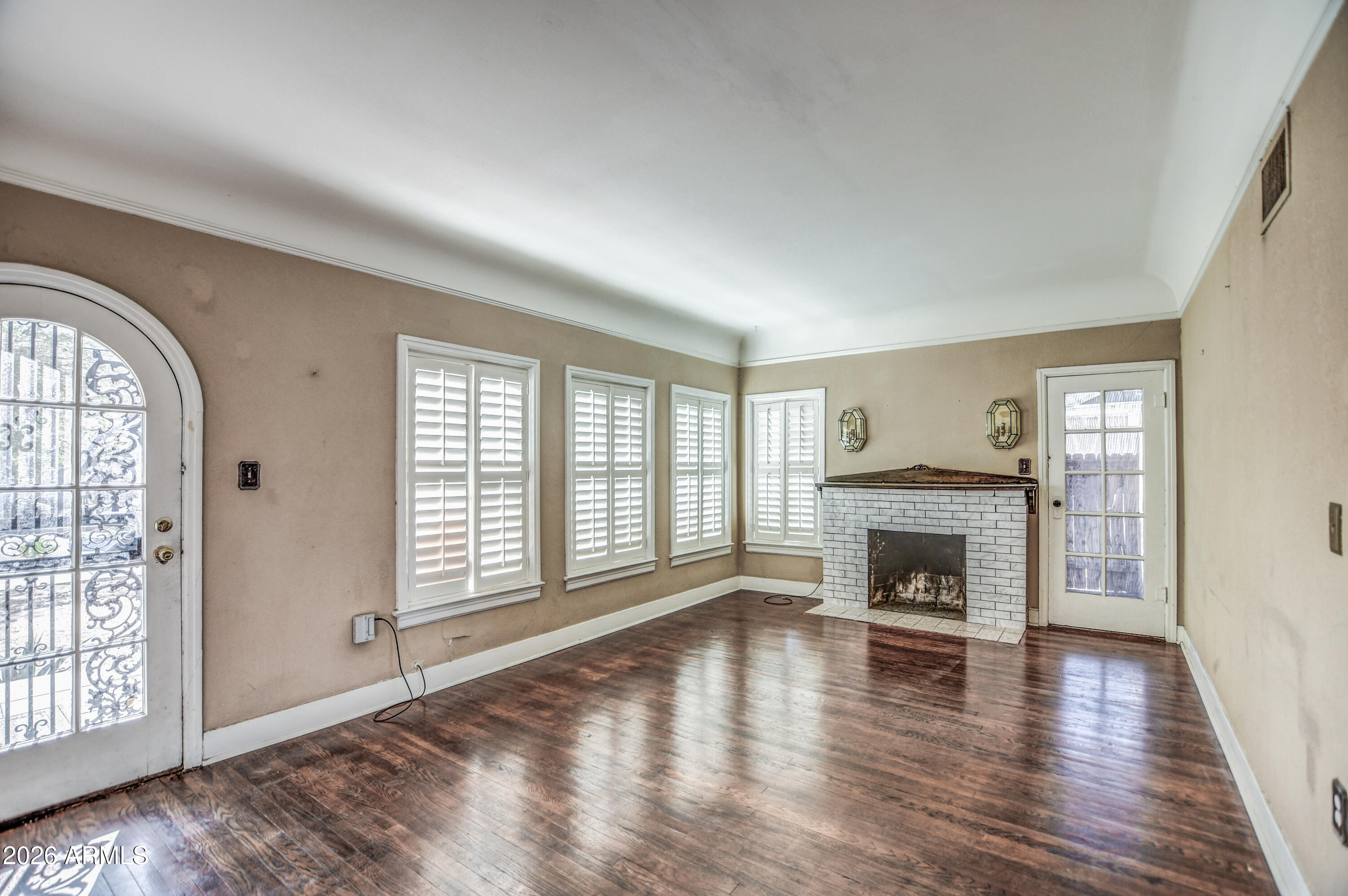 384 East Windsor Avenue Phoenix, AZ 85004 - Photo 5 of 42 an empty room with wooden floor fireplace and windows