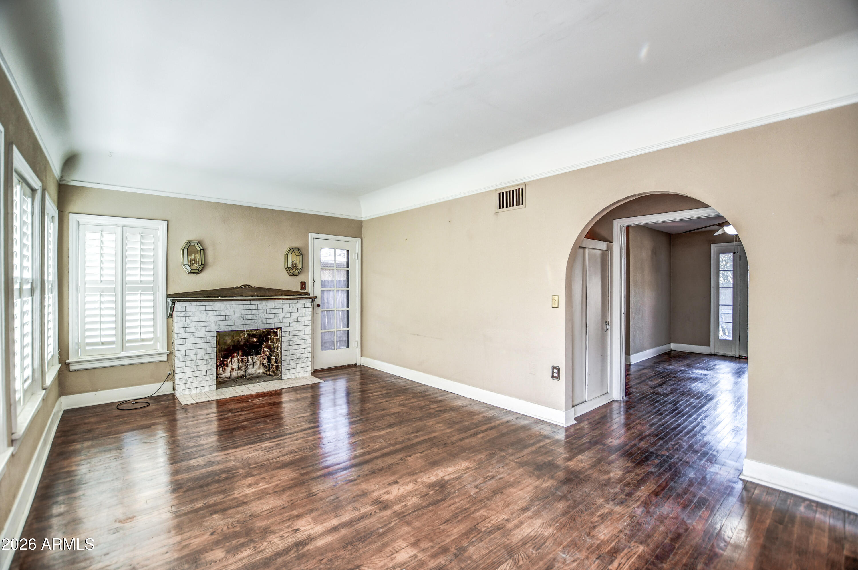 384 East Windsor Avenue Phoenix, AZ 85004 - Photo 8 of 42 an empty room with wooden floor fireplace and windows