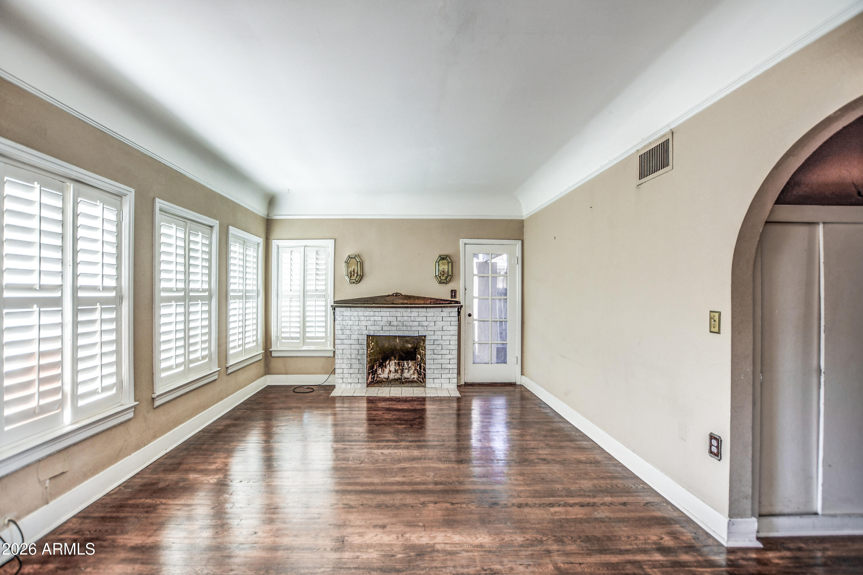 384 East Windsor Avenue Phoenix, AZ 85004 - Photo 9 of 42 a view of empty room with wooden floor and fireplace