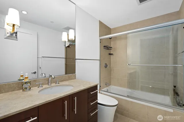 a view of an empty room with wooden floor and a flat screen tv