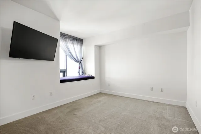 a view of an empty room with a window and a flat screen tv