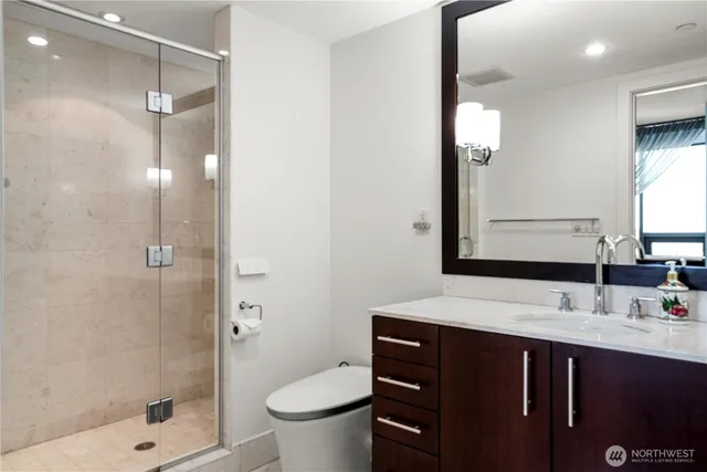 a bathroom with a sink vanity toilet and shower