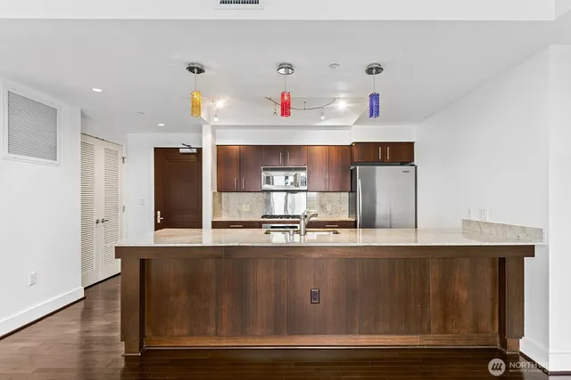 a kitchen with stainless steel appliances granite countertop a sink and refrigerator