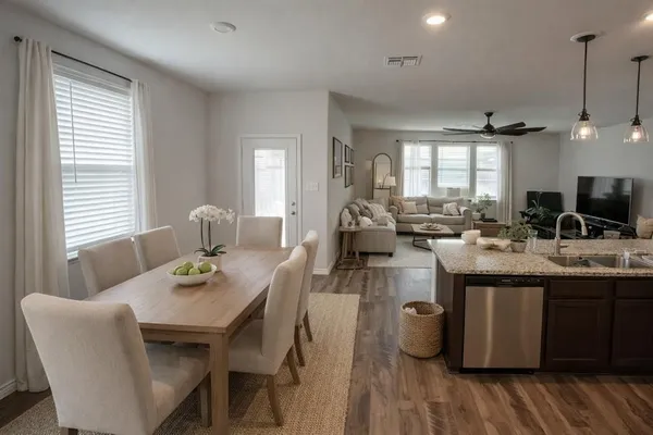 a kitchen with sink dining table and chairs
