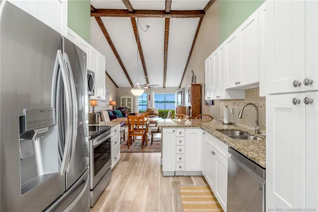 a bedroom with a bed a chandelier and large window