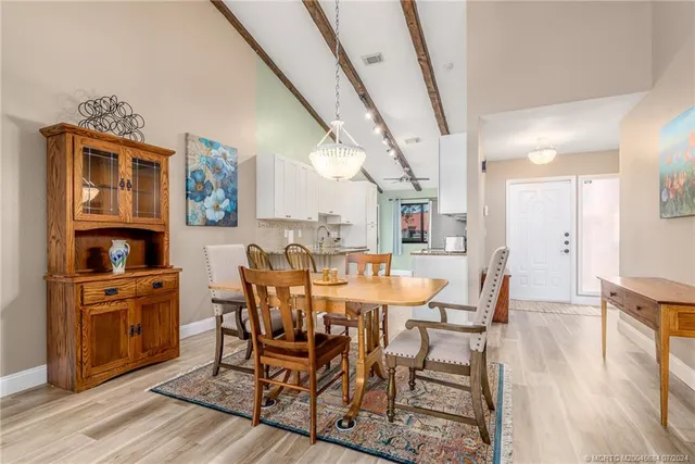 a kitchen with stainless steel appliances granite countertop a refrigerator a stove a sink a stove and a microwave oven with white cabinets