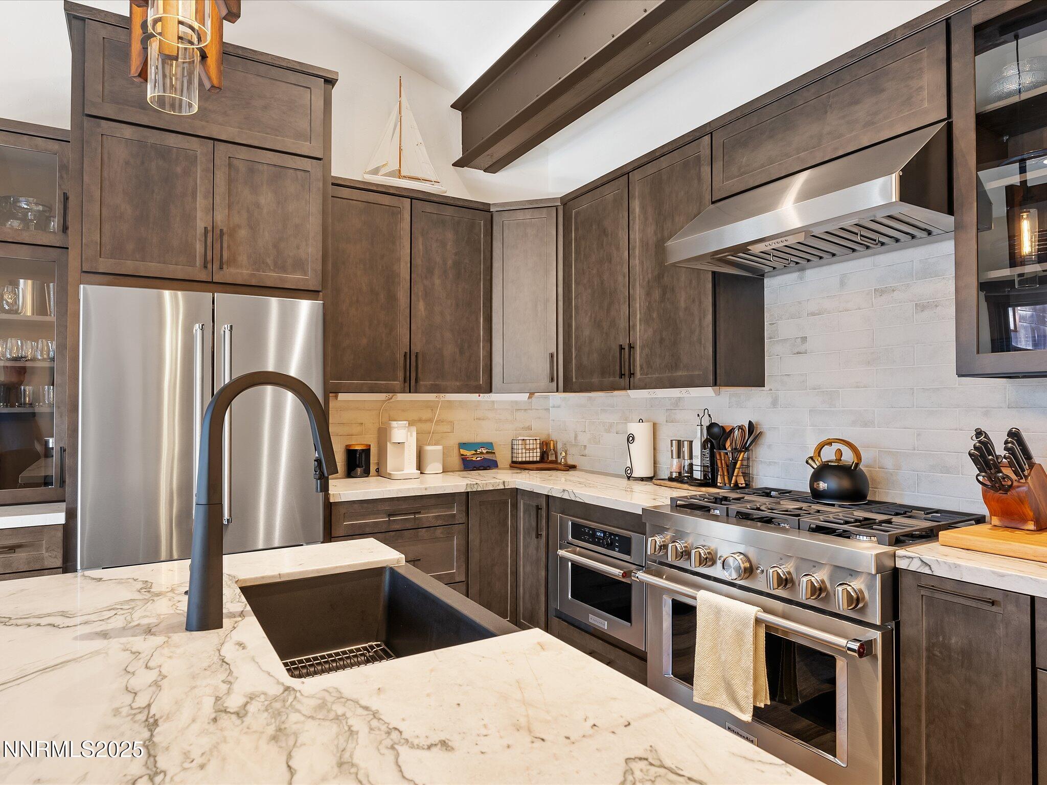 600 Highway 50, Unit 60 Zephyr Cove, NV 89448 - Photo 5 of 59 a kitchen with stainless steel appliances granite countertop a stove a sink dishwasher and a refrigerator with wooden cabinets