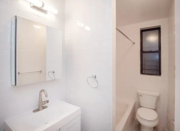 a bathroom with a toilet sink vanity and mirror