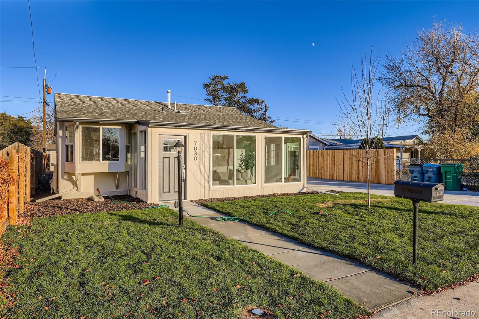 a view of a house with a big yard and potted plants