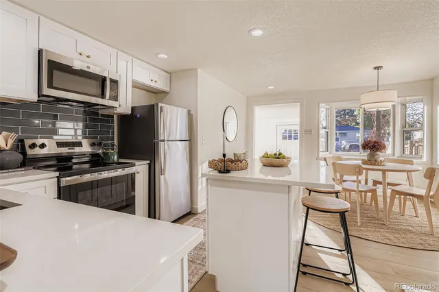 a kitchen with stainless steel appliances granite countertop a refrigerator stove microwave and sink