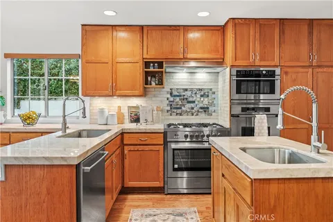 a kitchen with stainless steel appliances granite countertop a sink stove and refrigerator