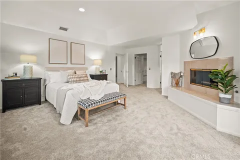 a bedroom with a bed lamps and mirror