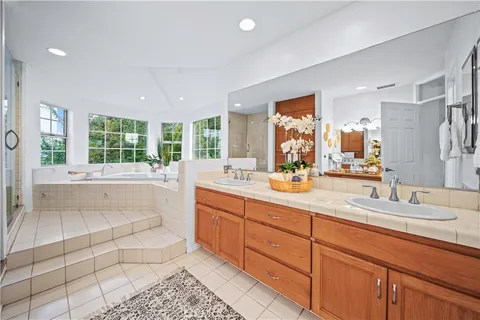 a spacious bathroom with a double vanity sink a mirror and a shower