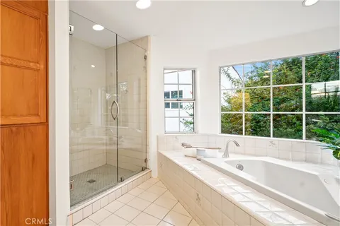 a bathroom with a large tub a shower and view