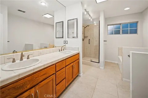 a spacious bathroom with a double vanity sink mirror and shower