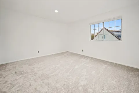 an empty room with a window and a wooden floor