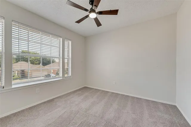 a view of backyard with wooden fence and a large tree