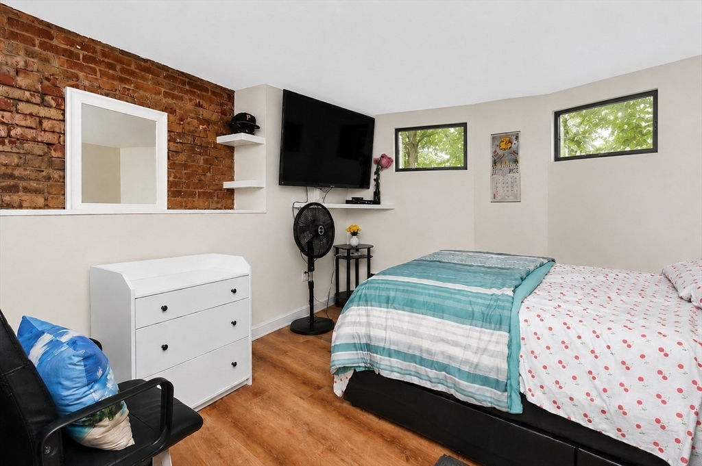 8 Colliston Road Boston, MA 02135 - Photo 27 of 40 a bedroom with a bed and flat tv screen on the dresser