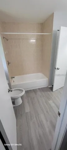 a bathroom with a white toilet and a tub