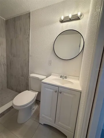 a bathroom with a toilet a sink and a mirror