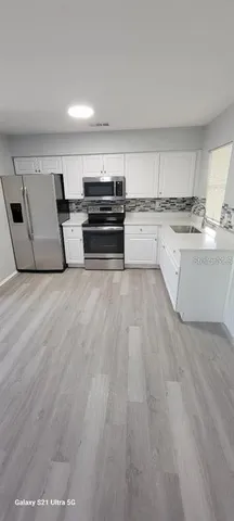 a view of kitchen with microwave and cabinets