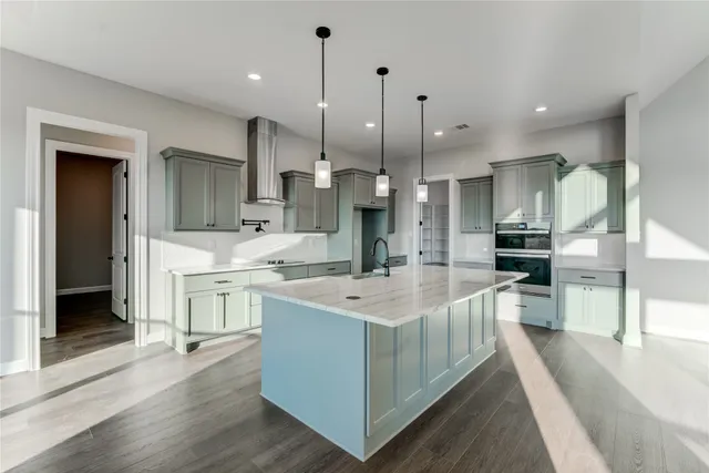 a kitchen with kitchen island a sink stainless steel appliances and cabinets