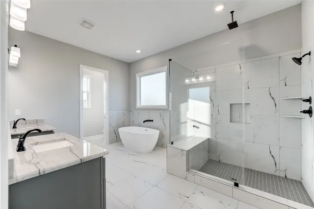 a spacious bathroom with a double vanity sink mirror and bathtub