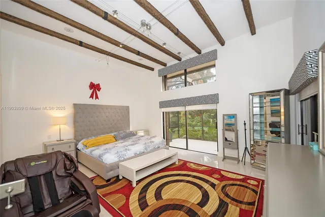 a bedroom with a bed and a large mirror on the dresser