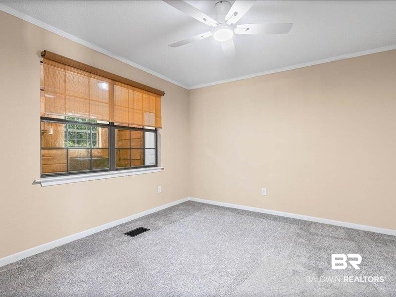 3160 Old Castleberry Road Brewton, AL 36426 - Photo 12 of 36 Neutral-toned interior with light tan walls, light gray carpet, and a white ceiling fan