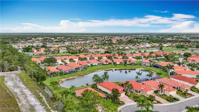 an aerial view of a city with lots of residential buildings ocean and mountain view in back