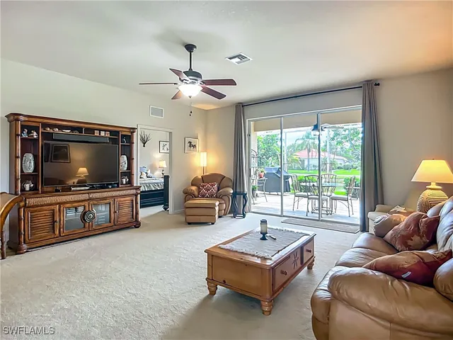 a living room with furniture a flat screen tv and a large window