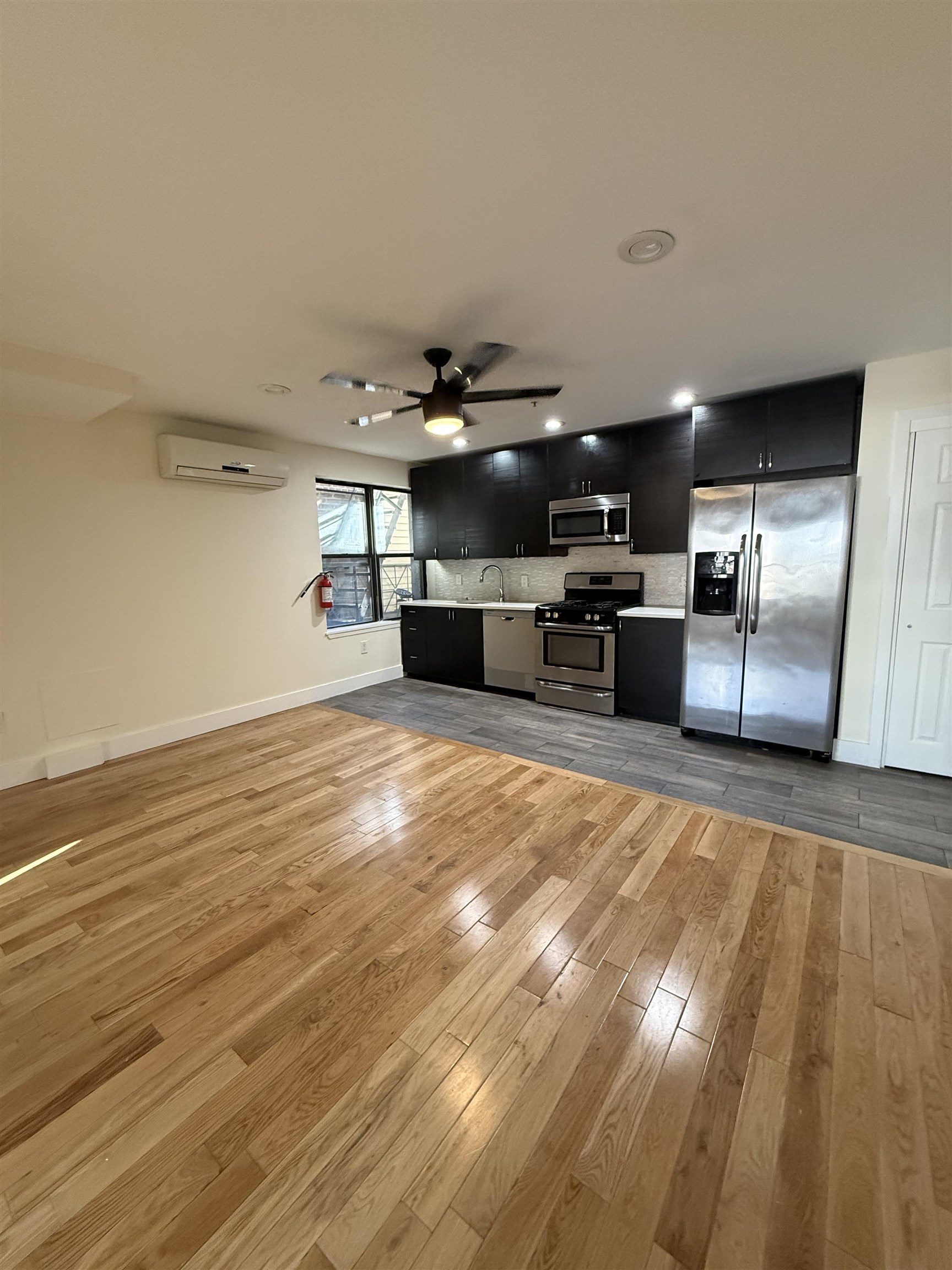 73-75 Ferry Street, Unit 7 Newark, NJ 07105 - Photo 3 of 11 a kitchen with stainless steel appliances kitchen island granite countertop a sink refrigerator stove and wooden floor