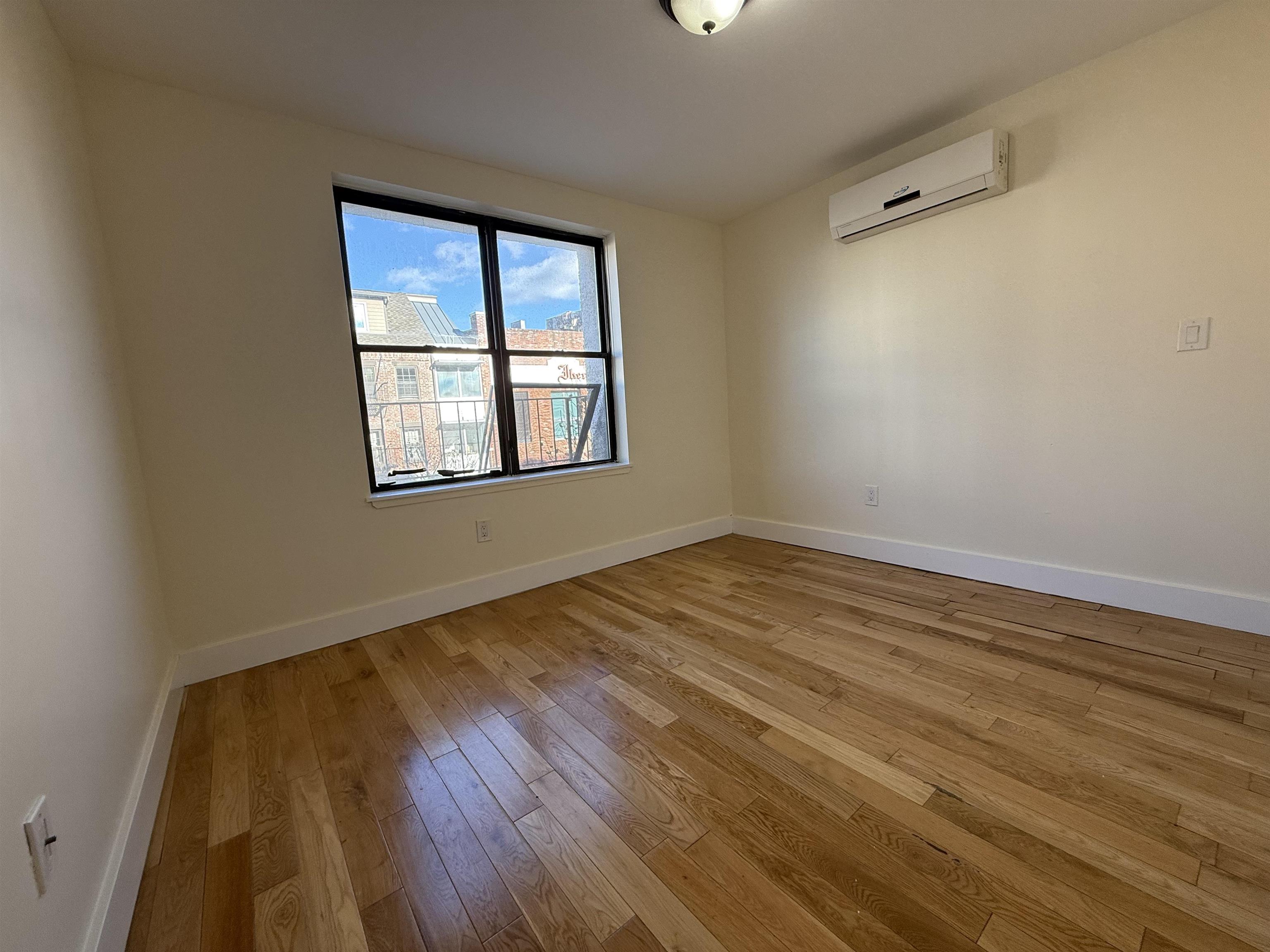 73-75 Ferry Street, Unit 7 Newark, NJ 07105 - Photo 10 of 11 an empty room with wooden floor and windows