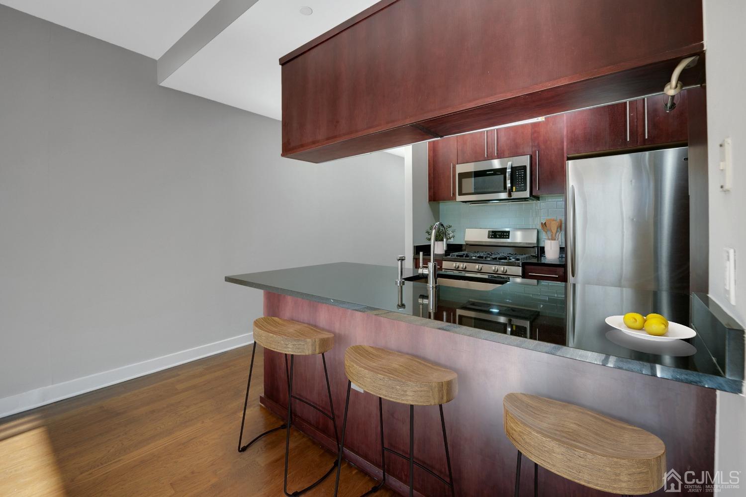 301 Hudson Park Edgewater, NJ 07020 - Photo 11 of 44 a kitchen with stainless steel appliances a dining table and chairs