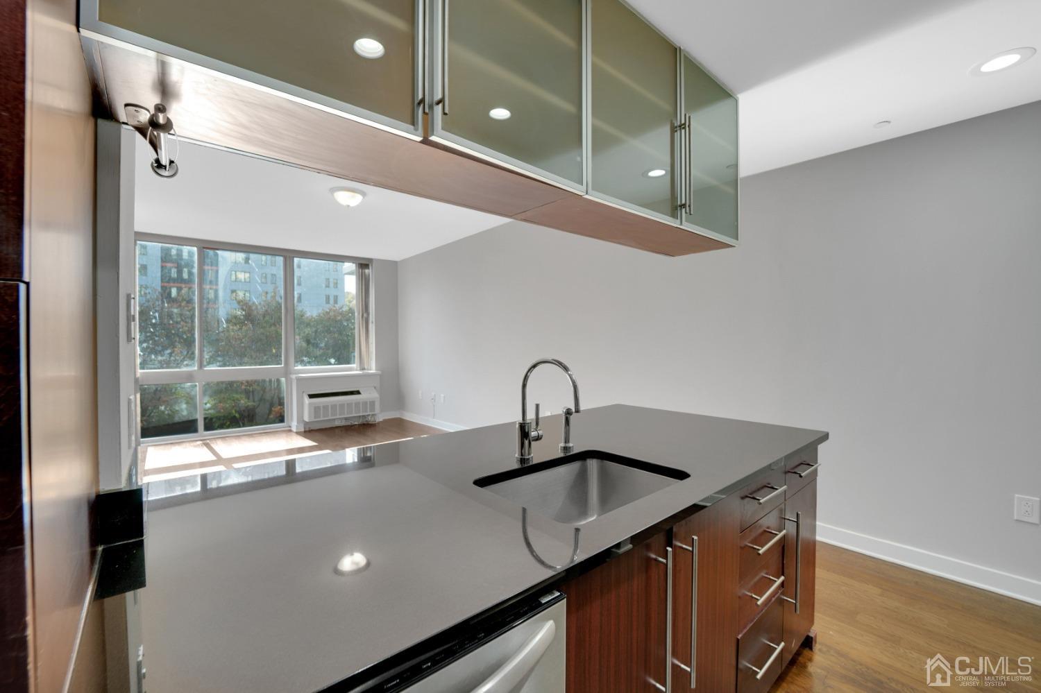 301 Hudson Park Edgewater, NJ 07020 - Photo 14 of 44 a kitchen with a sink a counter top space and living room view