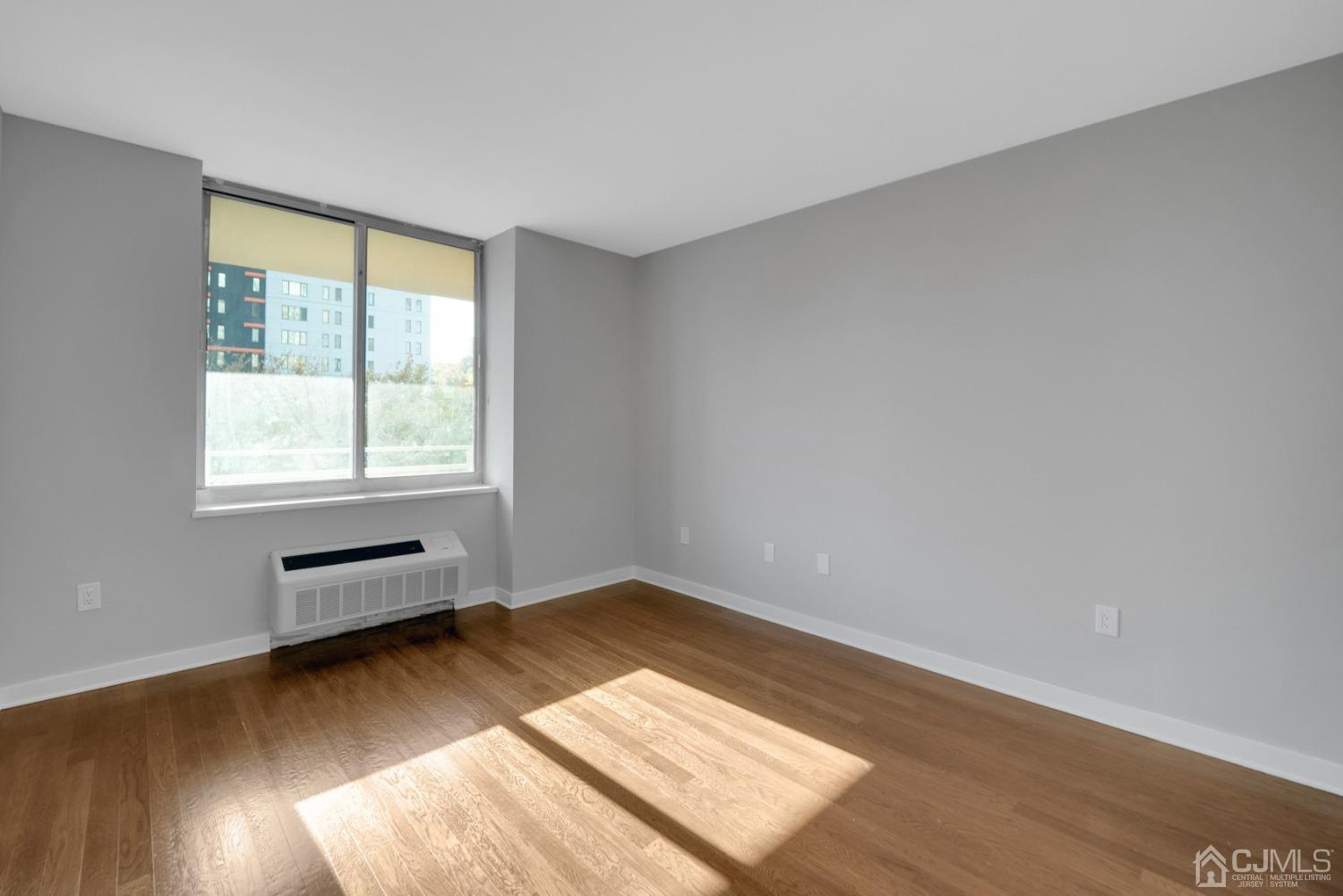 301 Hudson Park Edgewater, NJ 07020 - Photo 23 of 44 an empty room with wooden floor and windows